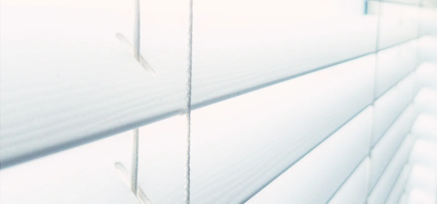 Close-up of white PVC venetian blind slats and ladder cords